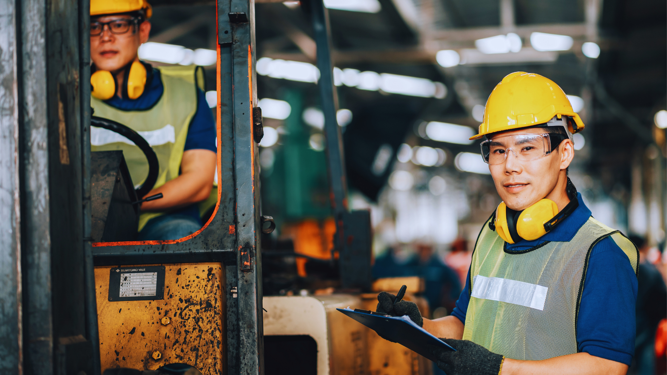 Warehouse worker with clipboard and forklift
